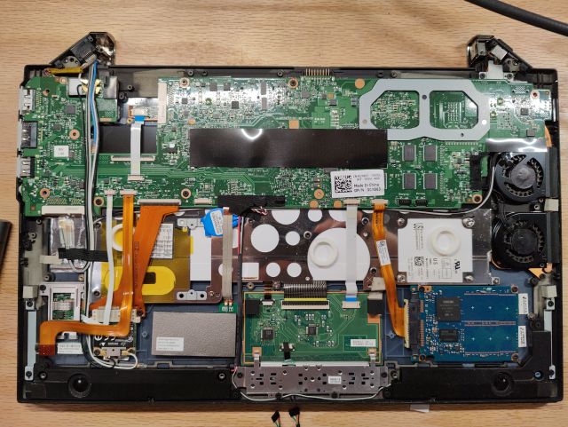 Dell Latitude Z600 laptop with the bottom cover off, displaying a horrifically complicated mess of ribbon cables and sub-modules