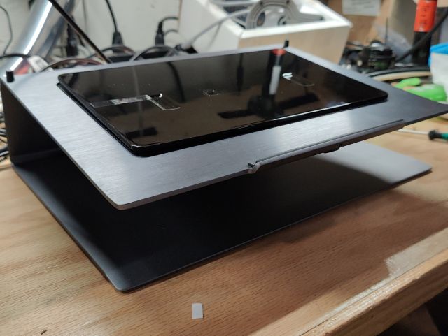 A metal laptop stand with a curious plastic panel protruding from the middle
